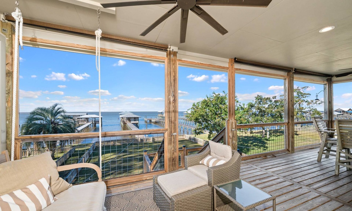 Alabama Gulf Coast House | A charming waterfront getaway on Mobile Bay featuring a private pier, cozy outdoor spaces, and beautiful bay views.