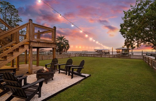 Alabama Gulf Coast House | A charming waterfront getaway on Mobile Bay featuring a private pier, cozy outdoor spaces, and beautiful bay views.